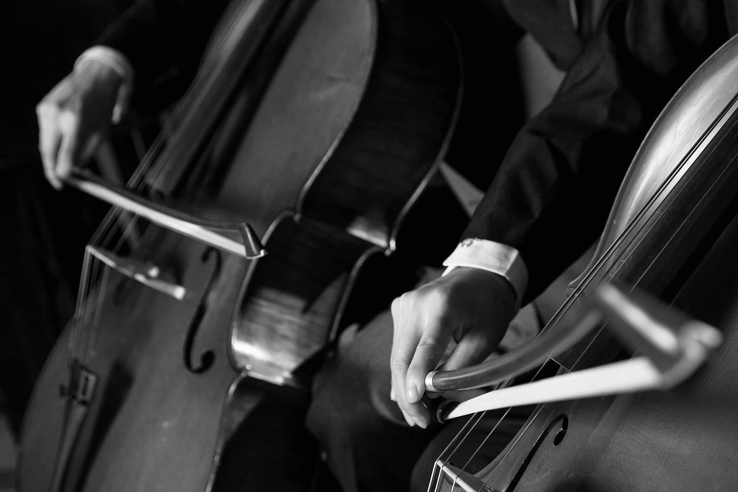 Close-up of midsection of two cellists playing the cello